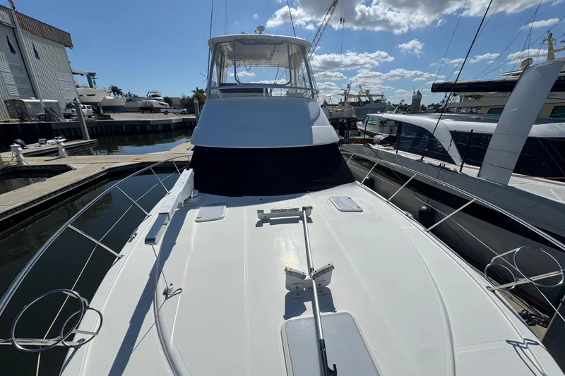 Slide: The Image of 2016 Riviera 43 Open Flybridge yacht docked at marina under blue sky. - 5