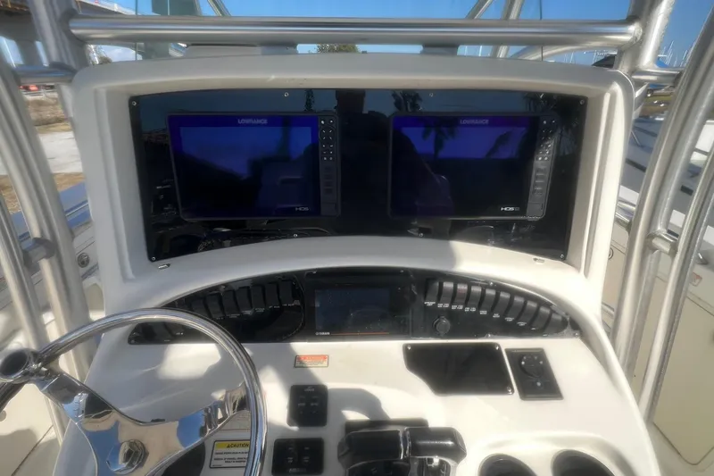 Slide: The Image of 2005 Boston Whaler 320 Outrage helm with dual Lowrance displays and steering wheel. - 12