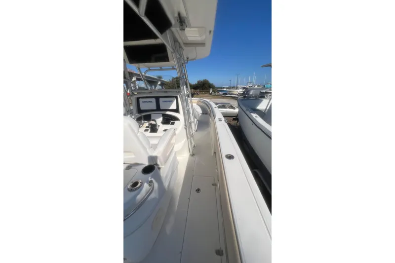 Slide: The Image of 2005 Boston Whaler 320 Outrage boat interior with navigation equipment, docked under clear blue sky. - 18
