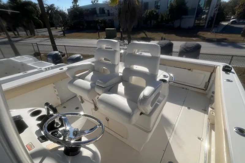 Slide: The Image of 2005 Boston Whaler 320 Outrage helm with dual white captain's chairs and steering wheel. - 21