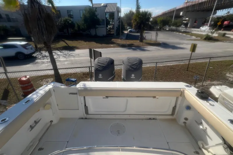 Slide: The Image of 2005 Boston Whaler 320 Outrage boat with Yamaha engines, docked near a road and bridge. - 24