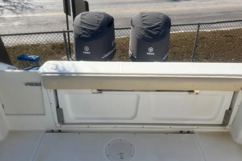 Slide: The Image of 2005 Boston Whaler 320 Outrage boat with Yamaha engine covers, docked near a fence. - 25