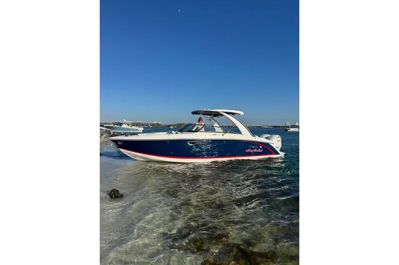 The Image of 2023 Cobalt 30SC Outboard boat on clear water under blue sky. - 0