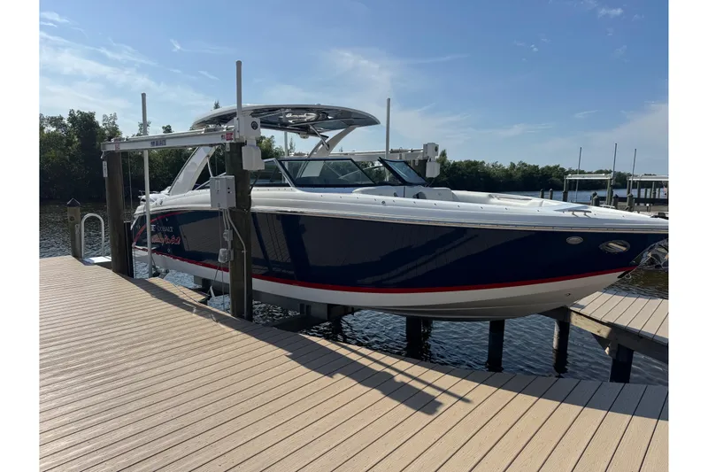 Slide: The Image of 2023 Cobalt 30SC Outboard boat docked on a sunny day. - 2