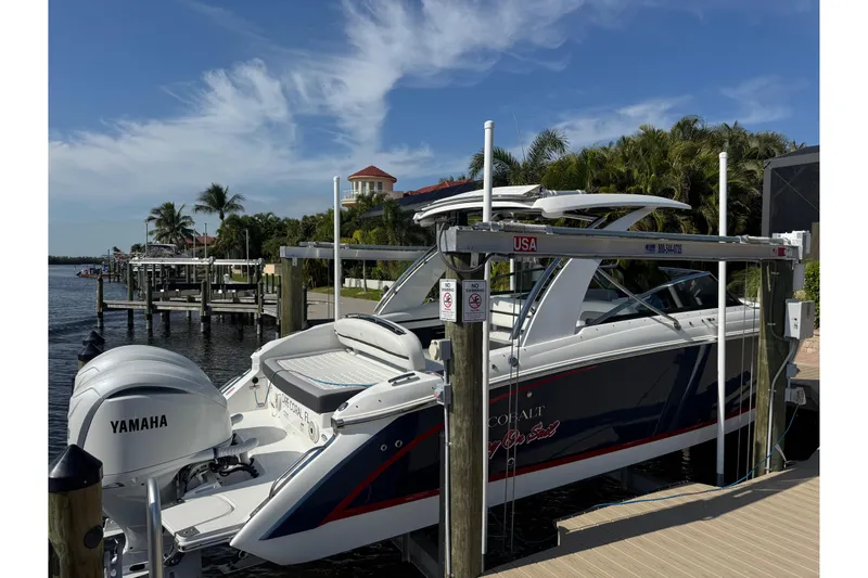 Slide: The Image of 2023 Cobalt 30SC Outboard boat docked with Yamaha engines, surrounded by palm trees. - 3