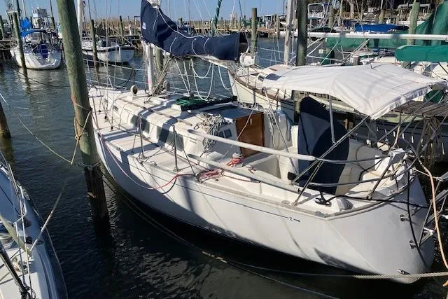 The Image of 1989 Sabre 30 sailboat docked in a marina, featuring a white hull and blue sail cover. - 0