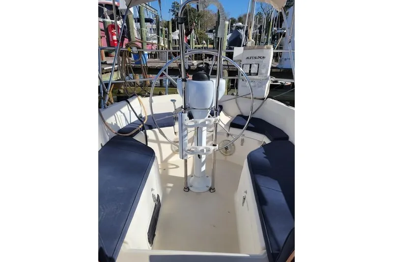Slide: The Image of 1989 Sabre 30 sailboat cockpit with steering wheel and blue cushioned seating. - 11