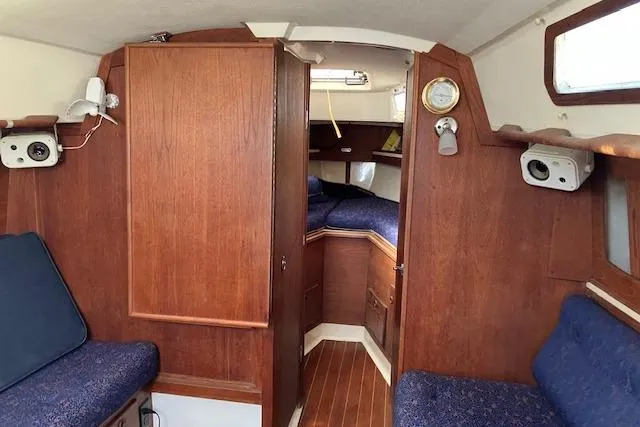 Slide: The Image of Interior of 1989 Sabre 30 sailboat with wooden cabinetry and blue seating. - 16