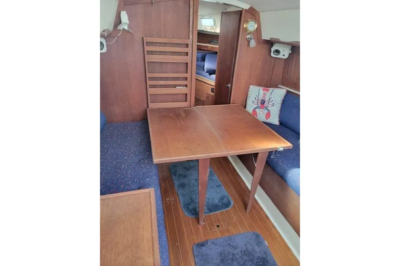 Slide: The Image of Interior of 1989 Sabre 30 sailboat with wooden table and blue seating. - 17