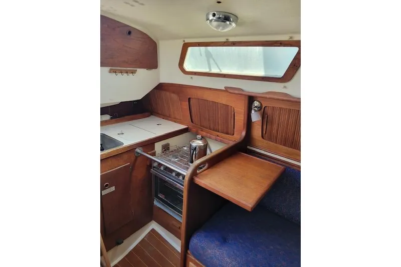 Slide: The Image of Cozy interior of a 1989 Sabre 30 sailboat with wooden cabinetry and seating. - 18