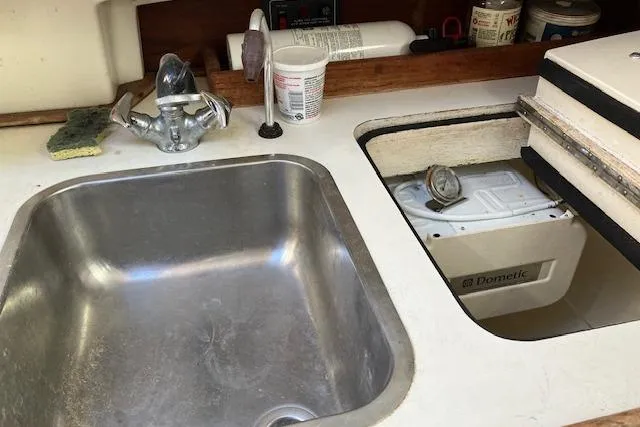 Slide: The Image of 1989 Sabre 30 yacht kitchen sink with faucet and storage area. - 19