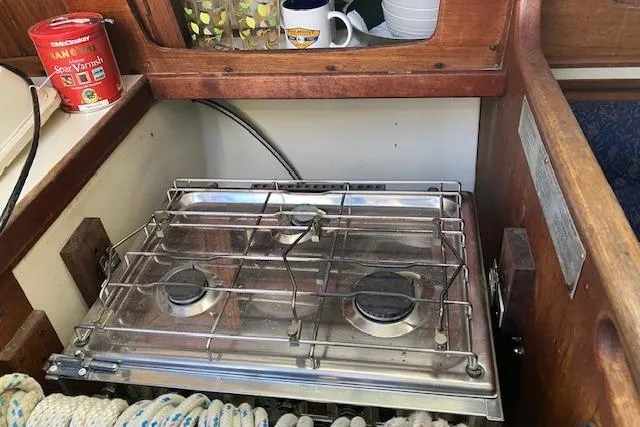 Slide: The Image of 1989 Sabre 30 yacht kitchen with stove, rope, and storage shelves. - 20