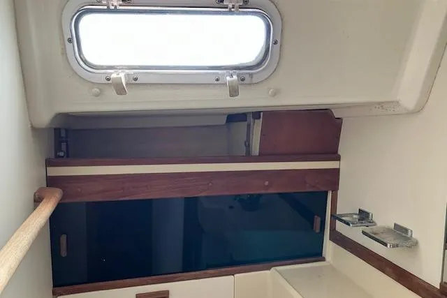Slide: The Image of 1989 Sabre 30 yacht interior with wooden accents and a porthole window. - 28