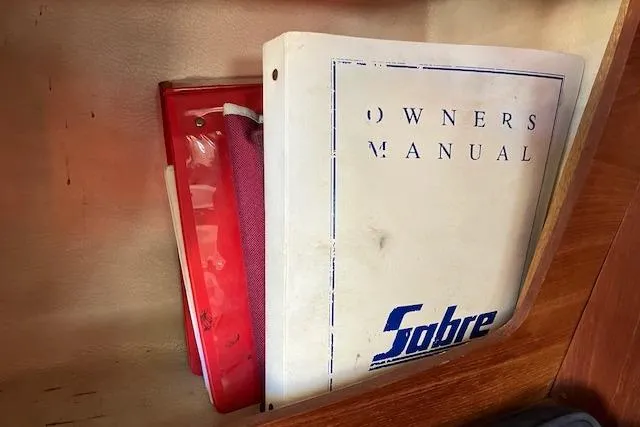 Slide: The Image of Owner's manual for 1989 Sabre 30 sailboat in a wooden shelf. - 30