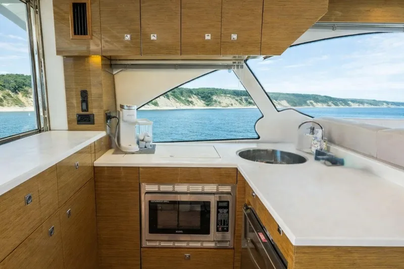 Slide: The Image of Luxurious 2018 Cruisers Yachts 50 Cantius kitchen with ocean view, featuring modern appliances. - 12
