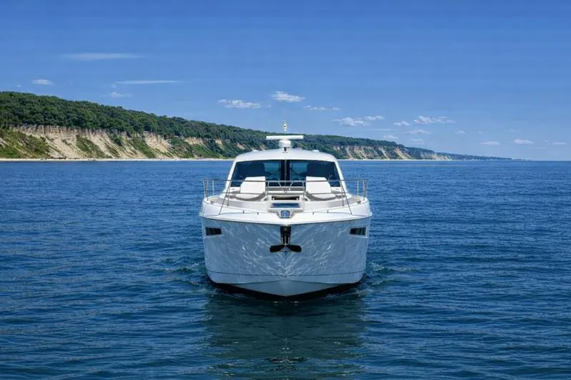 Slide: The Image of 2018 Cruisers Yachts 50 Cantius on open water with scenic coastline backdrop. - 3