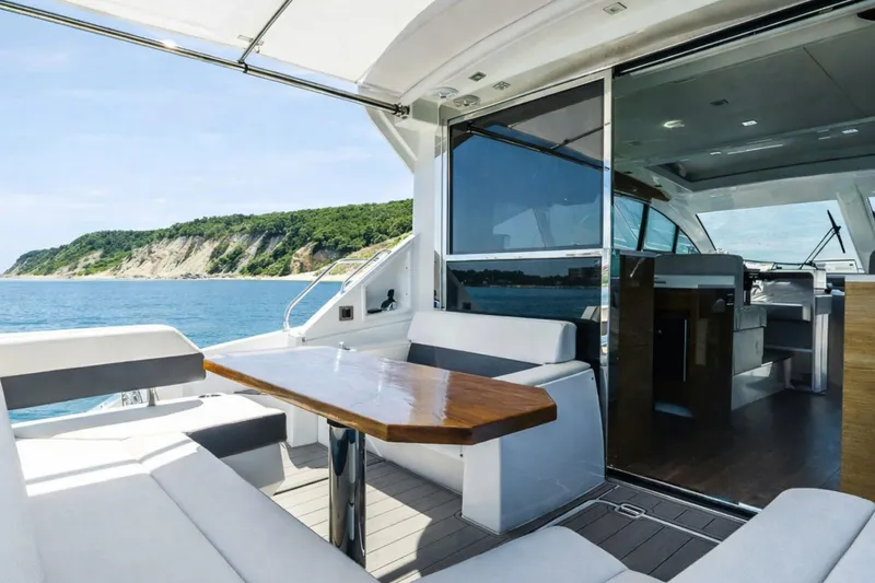 Slide: The Image of 2018 Cruisers Yachts 50 Cantius interior with ocean view, featuring sleek seating and modern design. - 7