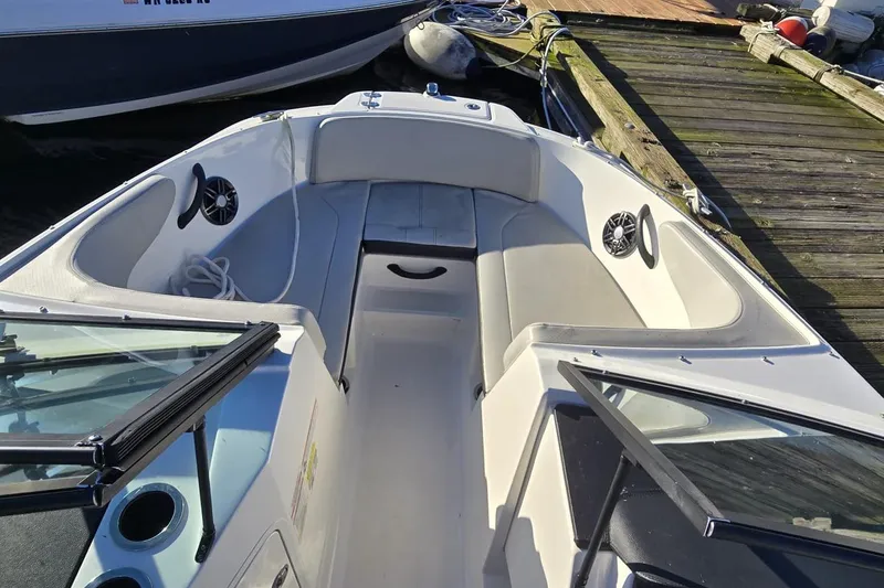 Slide: The Image of 2023 Sea Ray SPX 210 Outboard boat interior with seating and speakers at dock. - 17
