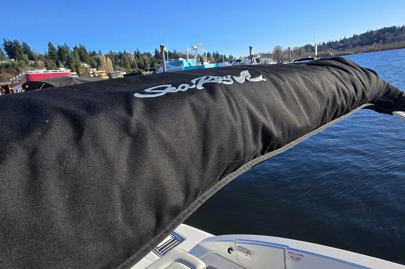 Slide: The Image of 2023 Sea Ray SPX 210 Outboard boat with cover on a sunny day by the water. - 19