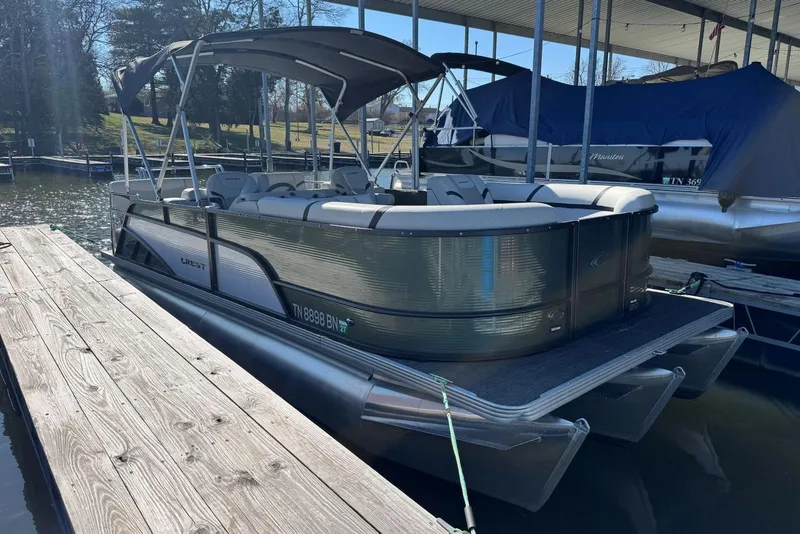 The Image of 2024 Crest Classic LX 220 SLRC pontoon boat docked at a marina. - 1