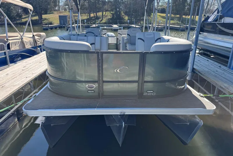 Slide: The Image of 2024 Crest Classic LX 220 SLRC pontoon boat docked on a sunny day. - 11