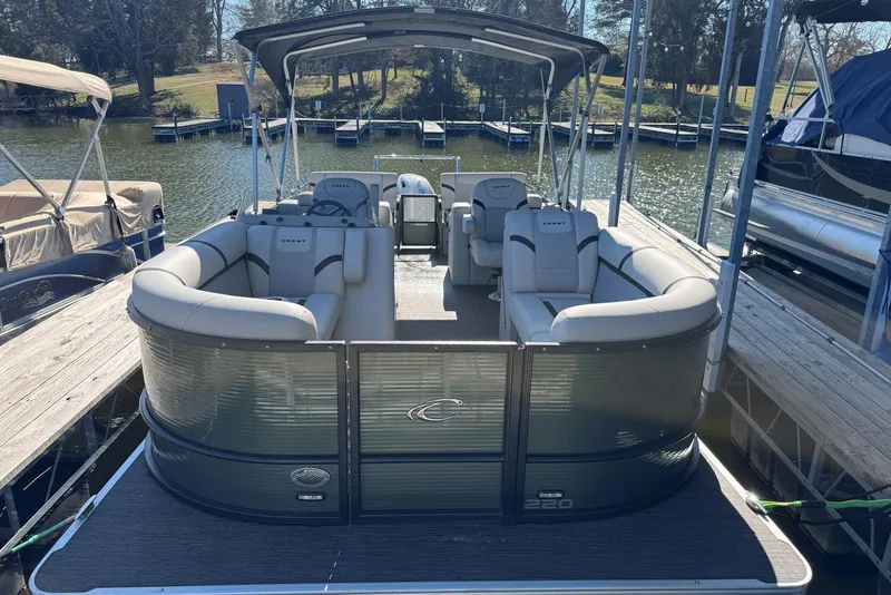 Slide: The Image of 2024 Crest Classic LX 220 SLRC pontoon boat docked on a sunny day. - 12