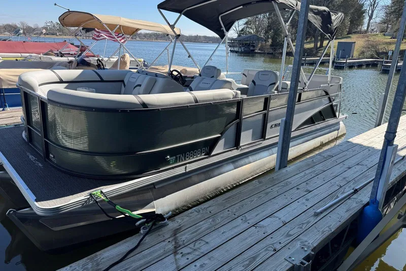 Slide: The Image of 2024 Crest Classic LX 220 SLRC pontoon boat docked on a sunny day. - 13