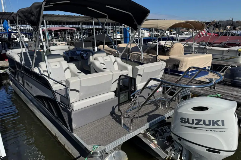 Slide: The Image of 2024 Crest Classic LX 220 SLRC pontoon boat with Suzuki engine at marina dock. - 15