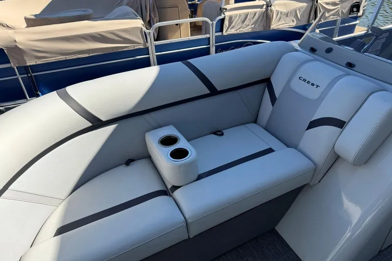 Slide: The Image of 2024 Crest Classic LX 220 SLRC boat interior with cushioned seating and cup holders. - 18