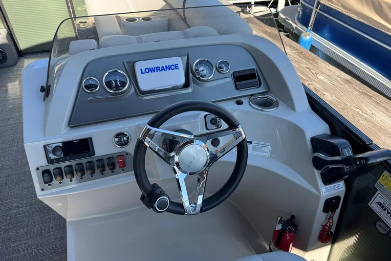 Slide: The Image of 2024 Crest Classic LX 220 SLRC boat dashboard with steering wheel and Lowrance display. - 22