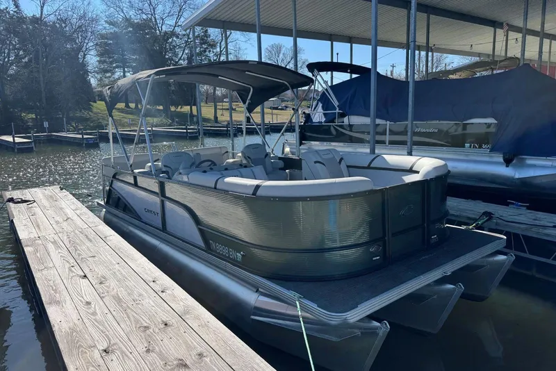Slide: The Image of 2024 Crest Classic LX 220 SLRC pontoon boat docked at a marina. - 3