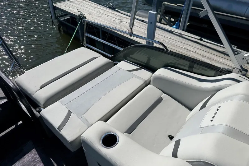 Slide: The Image of 2024 Crest Classic LX 220 SLRC boat with luxurious seating by the dock. - 31
