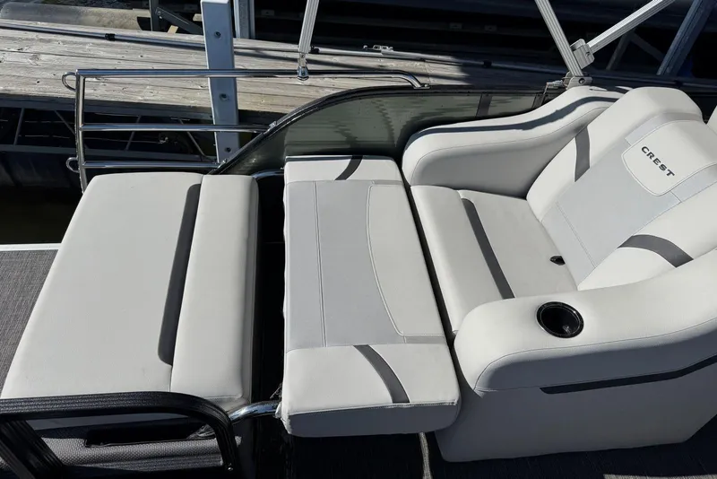 Slide: The Image of 2024 Crest Classic LX 220 SLRC boat seating with cup holder, docked at marina. - 32