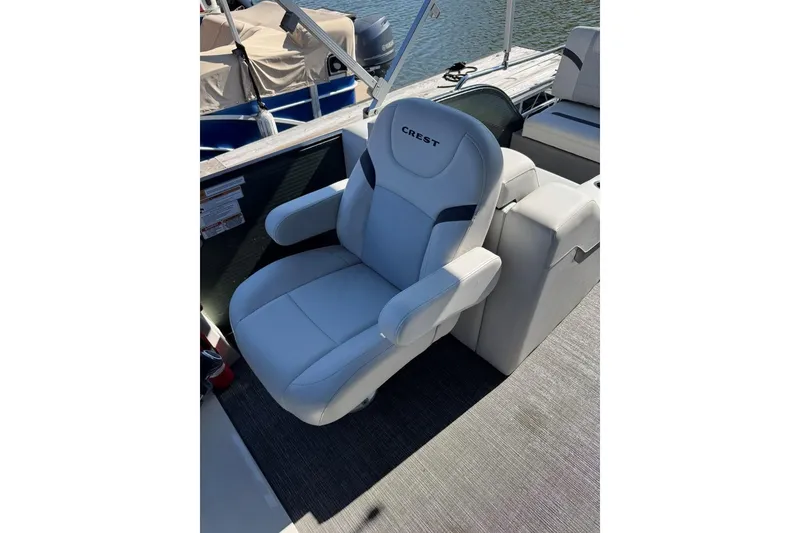 Slide: The Image of 2024 Crest Classic LX 220 SLRC boat seat, white and gray, on deck. - 38