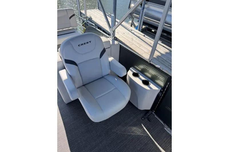 Slide: The Image of 2024 Crest Classic LX 220 SLRC boat seat with cup holders, dockside view. - 39