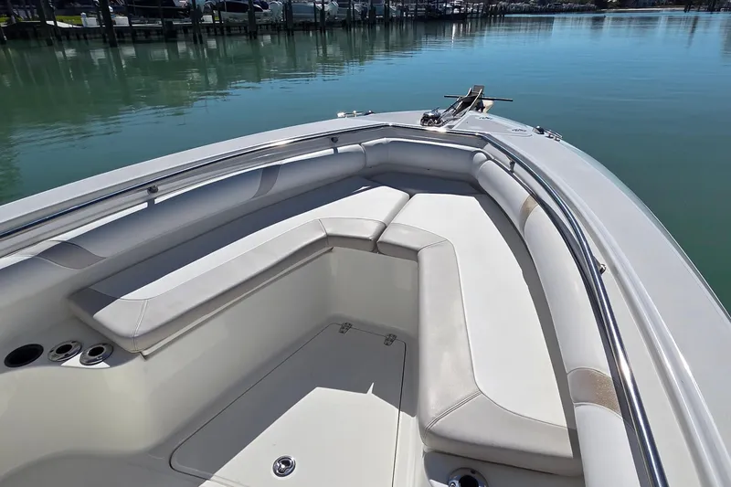 Slide: The Image of 2006 Boston Whaler 270 Outrage boat interior with cushioned seating and calm water backdrop. - 11