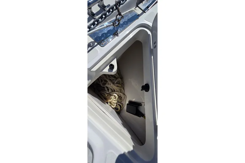 Slide: The Image of Storage compartment on a 2006 Boston Whaler 270 Outrage boat with coiled rope. - 15