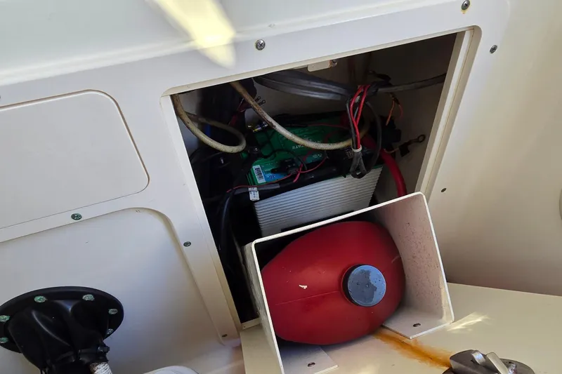 Slide: The Image of 2006 Boston Whaler 270 Outrage battery compartment with wiring and red fuel tank. - 23