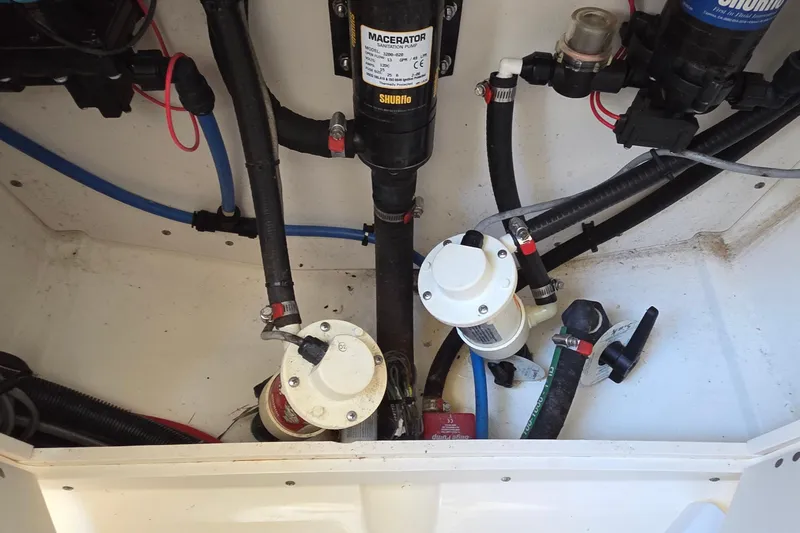 Slide: The Image of 2006 Boston Whaler 270 Outrage bilge area with macerator pump and plumbing components. - 26