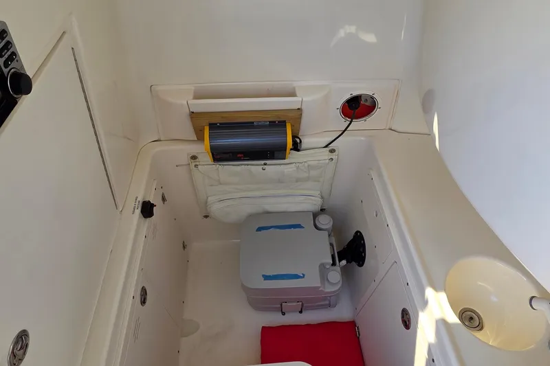 Slide: The Image of 2006 Boston Whaler 270 Outrage interior with portable toilet and equipment storage. - 27