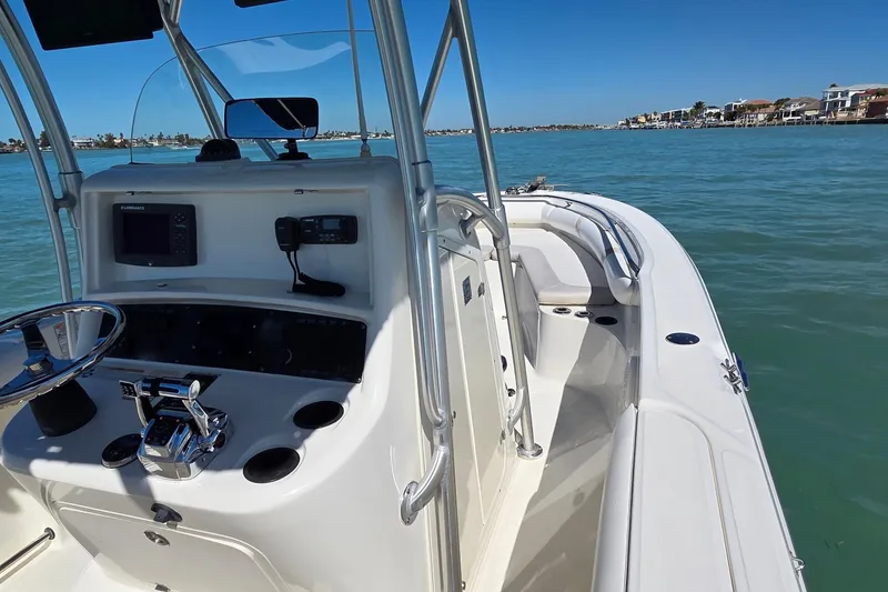 Slide: The Image of 2006 Boston Whaler 270 Outrage boat on calm water, featuring a sleek console and seating. - 32