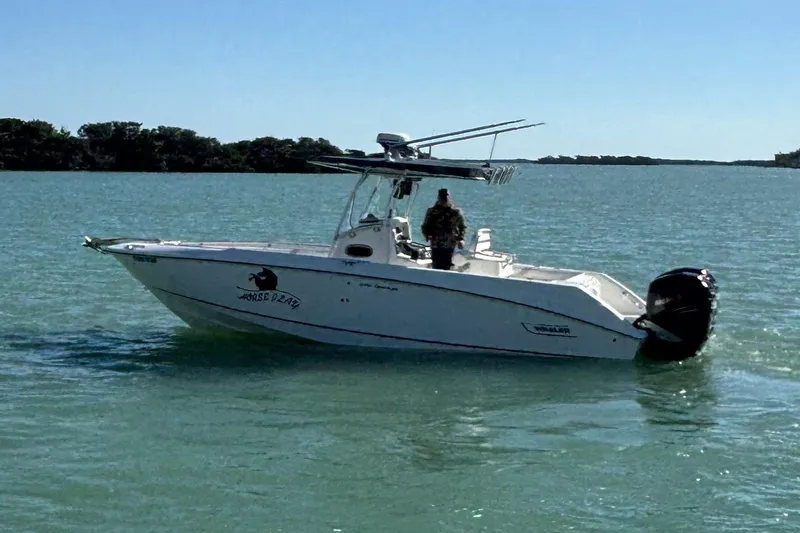 Slide: The Image of 2006 Boston Whaler 270 Outrage boat on calm water, clear sky background. - 48