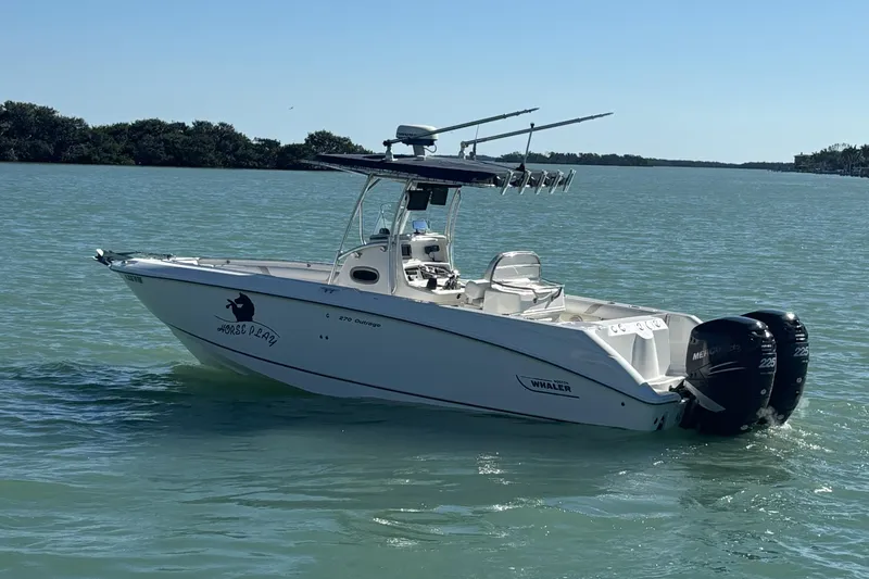 Slide: The Image of 2006 Boston Whaler 270 Outrage boat on calm water with twin engines. - 49