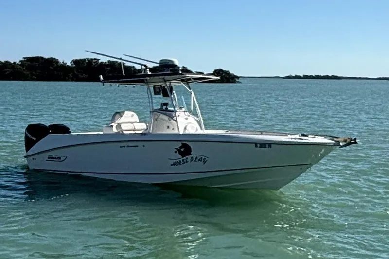 Slide: The Image of 2006 Boston Whaler 270 Outrage boat on calm water, clear sky background. - 52