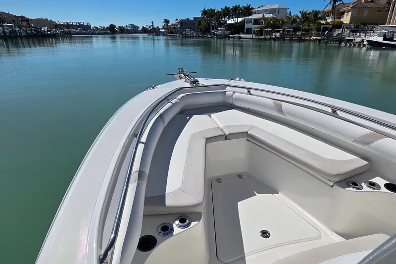 Slide: The Image of 2006 Boston Whaler 270 Outrage boat with spacious seating, docked in a serene marina. - 9
