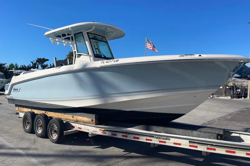 The Image of 2025 Boston Whaler 280 Outrage boat on trailer, clear blue sky background. - 13