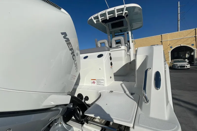 Slide: The Image of 2025 Boston Whaler 280 Outrage boat with Mercury engine, docked under clear blue sky. - 18