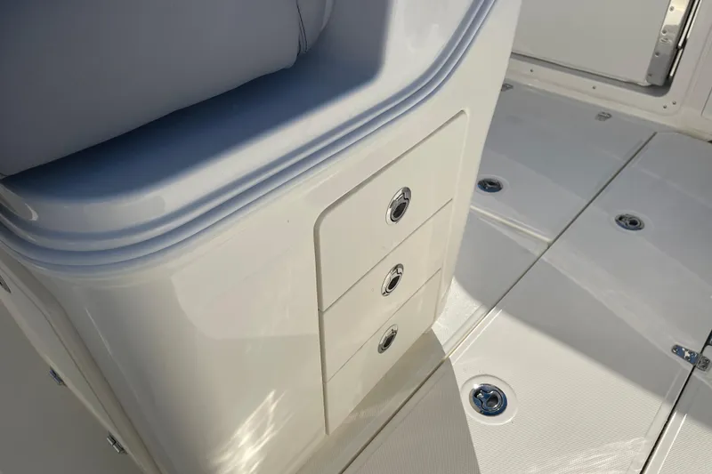 Slide: The Image of 2025 Boston Whaler 280 Outrage interior storage compartments and seating detail. - 32