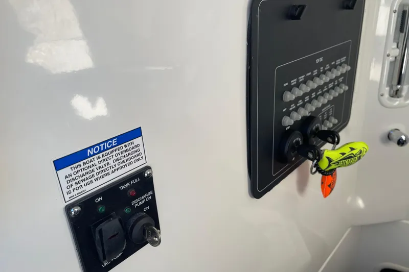 Slide: The Image of Control panel of 2025 Boston Whaler 280 Outrage boat with safety notice and keys. - 35
