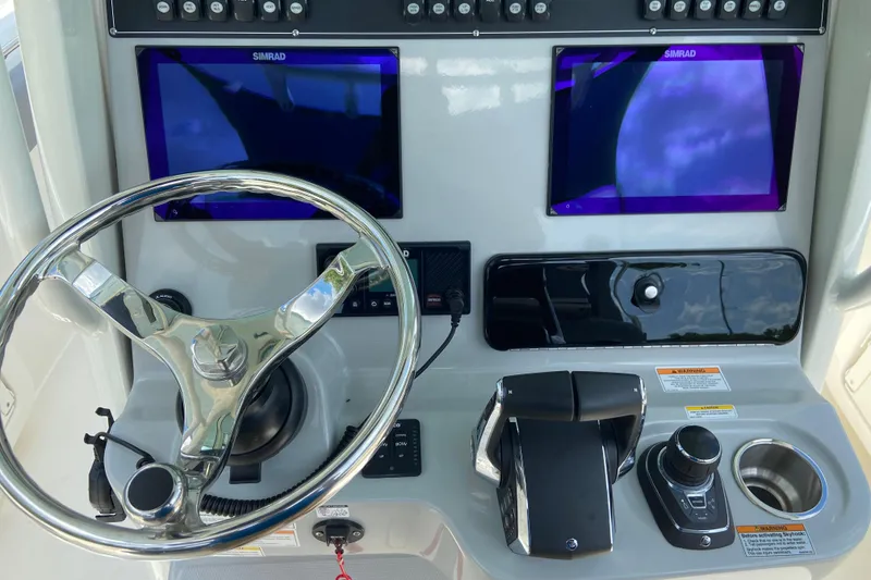 Slide: The Image of Helm of 2025 Boston Whaler 280 Outrage with dual Simrad displays and controls. - 38